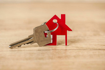 关键房子形状的钥匙链安排木背景真正的房地产保险概念抵押贷款买出售房子房地产经纪人概念