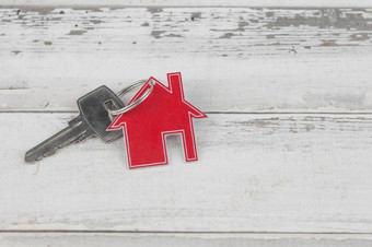 关键房子形状的钥匙链安排白色木背景前视图平躺真正的房地产保险概念抵押贷款买出售房子房地产经纪人概念