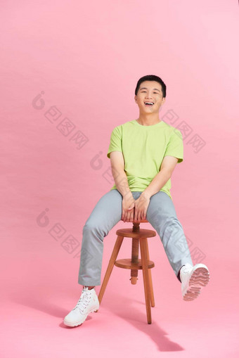 年轻的男人。白色t恤坐着高椅子