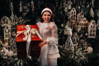 女孩圣诞老人他大圣诞节礼物手童话语言岛微笑女人白色衣服背景圣诞节树小房子