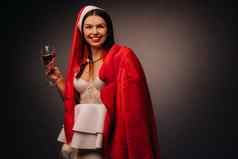 女人圣诞节他白色衣服持有玻璃红色的皮毛外套手黑色的背景圣诞节假期