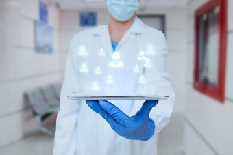 医生统一的站持有平板电脑几乎打字笔护士携带垫打字显示医疗未来主义的技术