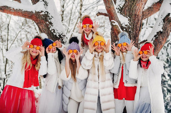 大集团女孩橘子站冬天森林女孩红色的白色衣服水果白雪覆盖的森林