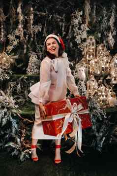 女孩圣诞老人他大圣诞节礼物手童话语言岛微笑女人白色衣服背景圣诞节树小房子