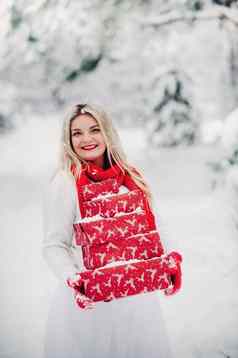 女孩白色毛衣圣诞节礼物手站白雪覆盖的森林女人圣诞节礼物冬天