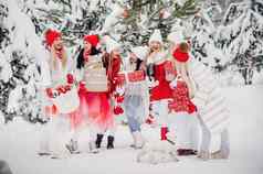 大集团女孩圣诞节礼物手站冬天森林女孩红色的白色衣服圣诞节礼物雪森林