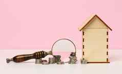 堆栈金属钱放大镜木房子粉红色的背景真正的房地产租赁