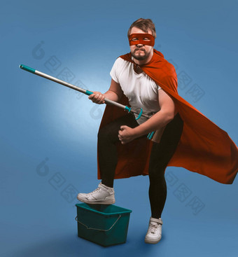 超级英雄准备好了清洁工作男人。面具超级英雄红色的斗篷摆姿势桶拖把展示岩石音乐家孤立的蓝色的背景