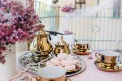精致的早....茶表格设置淡紫色花古董勺子菜表格粉红色的桌布
