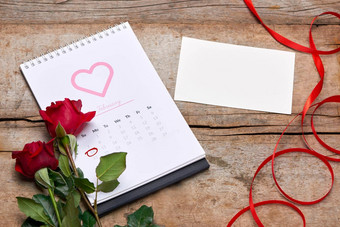 日历显示日期2月红色的玫瑰心礼物盒子木表格