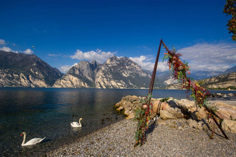 白色天鹅拱婚礼仪式湖泻湖加尔达高山景观意大利