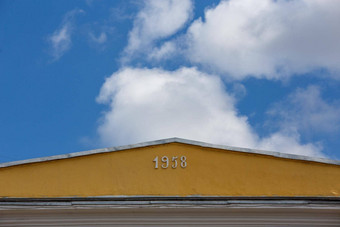 特写镜头视图黄色的屋顶脊白数字蓝色的天空白色云背景
