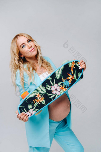 怀孕了女孩绿松石衣服滑板手灰色的背景