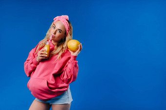 怀孕了女孩粉红色的衣服瓶汁瓜蓝色的背景