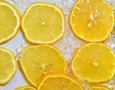 柠檬特写镜头液体泡沫片黄色的成熟的柠檬水特写镜头新鲜的片柠檬白色背景