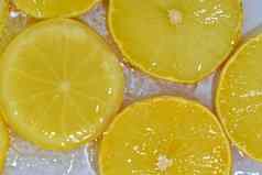 柠檬特写镜头液体泡沫片黄色的成熟的柠檬水特写镜头新鲜的片柠檬白色背景