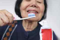 亚洲上了年纪的女人牙刷手地震牙科健康