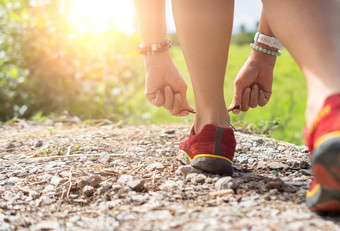 女人穿运行鞋走运行自然绿色背景健康锻炼