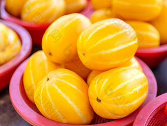 美味的朝鲜文条纹黄色的瓜水果食物红色的塑料篮子传统市场下午首尔南韩国收获概念关闭