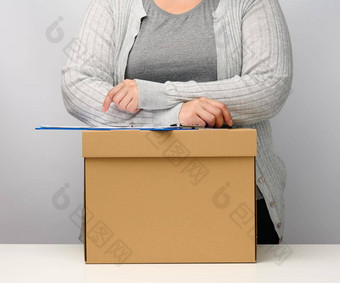 女人灰色的衣服站棕色（的）盒子概念移动发送接<strong>收货</strong>物解雇工作