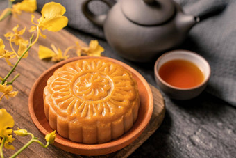中秋节日传统的食物概念美丽的月亮蛋糕黑色的板岩表格茶糕点模具花关闭复制空间