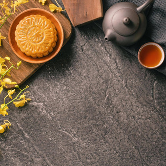 中秋节日传统的食物概念美丽的月亮蛋糕黑色的板岩表格茶糕点模具花前视图平躺复制空间