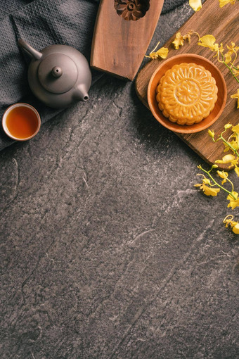 <strong>中秋</strong>节日传统的食物概念美丽的月亮蛋糕黑色的板岩表格茶糕点模具花前视图平躺复制空间