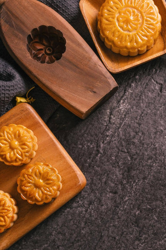 中秋节日传统的食物概念美丽的月亮蛋糕黑色的板岩表格茶糕点模具花前视图平躺复制空间