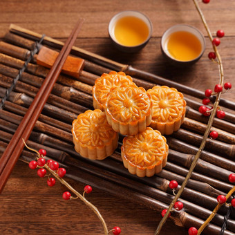中国人传统的糕点月亮蛋糕月饼茶杯竹子服务托盘木背景中秋节日前视图平躺