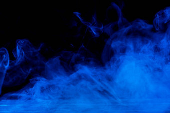概念上的图像蓝色的烟孤立的<strong>黑暗黑</strong>色的<strong>背景</strong>木表格