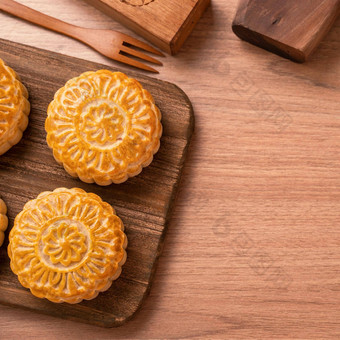 轮形状的新鲜的烤月亮蛋糕糕点中国人穆安卡中秋月亮节日木背景服务托盘前视图平躺