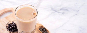 木薯珍珠球泡沫牛奶茶受欢迎的台湾喝喝玻璃稻草大理石白色表格木托盘关闭复制空间