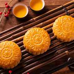 中国人传统的糕点月亮蛋糕月饼茶杯竹子servingwarning托盘木背景中秋节日关闭