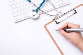 女医生写作医疗记录情况下剪贴板白色工作表格听诊器电脑键盘前视图平躺复制空间