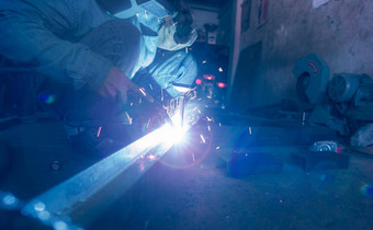 焊机焊接金属氩弧焊接机焊接火花男人。穿焊接面具保护手套安全工业工作场所焊机工作安全钢行业