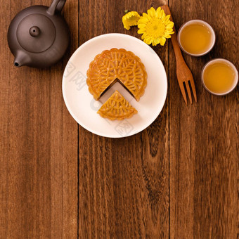月亮蛋糕茶黑暗木表格假期概念中秋节日传统的食物布局设计前视图平躺复制空间