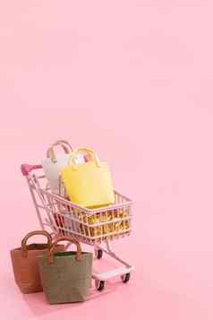年度出售购物季节概念迷你粉红色的商店车电车完整的纸袋礼物孤立的苍白的粉红色的背景空白复制空间关闭