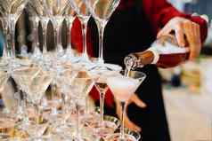 人持有瓶香槟服务金字塔美味的酒精水晶玻璃香槟浪漫的庆祝活动聚会，派对概念
