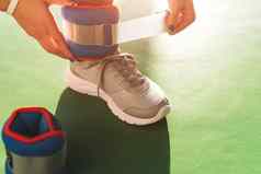女人把脚踝幽魂开始锻炼健身房健康健身概念