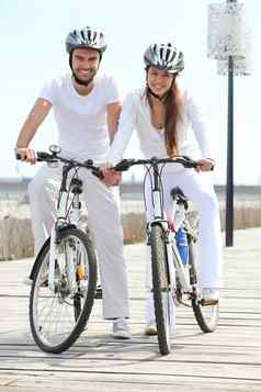 夫妇骑自行车穿周期头盔