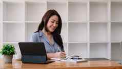 业务亚洲女人手采取笔记项目办公室表格在线会议在线学习概念