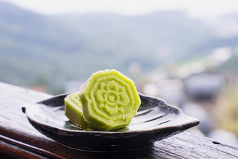 美味的绿色绿豆豆蛋糕黑色的茶板木栏杆茶馆台湾美丽的景观背景关闭