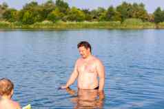 家庭父亲儿子游泳河热夏天一天游泳水库快乐家庭有趣的溅水夏天
