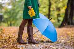 关闭照片伞女人靴子持有秋天叶子
