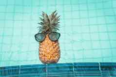夏天假期游泳池放松生活方式概念菠萝太阳镜在游泳池边海滩假期热带休闲活动放松假期度假胜地