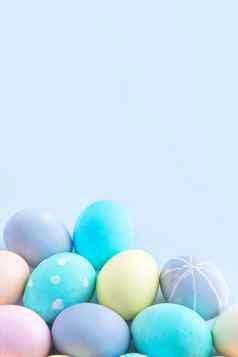 色彩斑斓的复活节鸡蛋染色彩色的水孤立的苍白的蓝色的背景设计概念复活节假期活动关闭复制空间