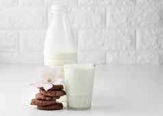 完整的玻璃杯牛奶清晰的塑料瓶牛奶堆栈轮巧克力芯片饼干白色表格