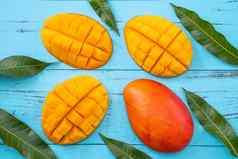 芒果新鲜的切碎热带芒果水果孤立的明亮的充满活力的光蓝色的木表格背景前视图平躺布局开销拍摄