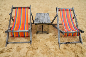 色彩斑斓的木休息室椅子沙子海滩