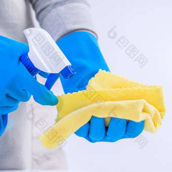 年轻的女人管家清洁白色表格围裙蓝色的手套喷雾更清洁的湿黄色的破布关闭复制空间空白设计概念